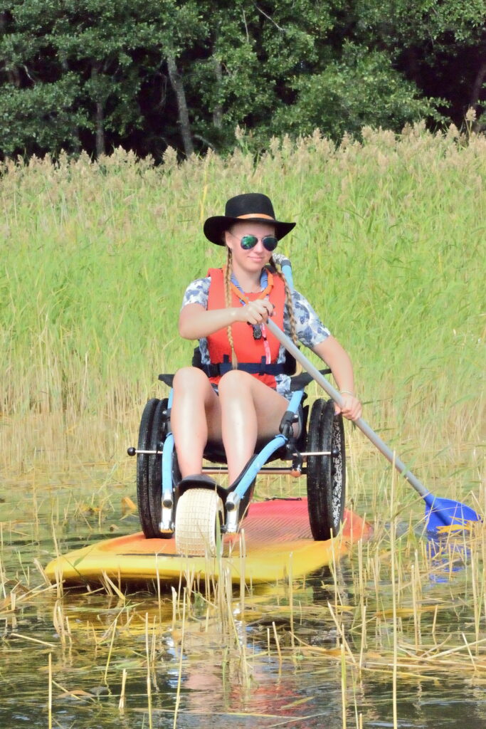 a scout paddeling on a board on a wheelchair